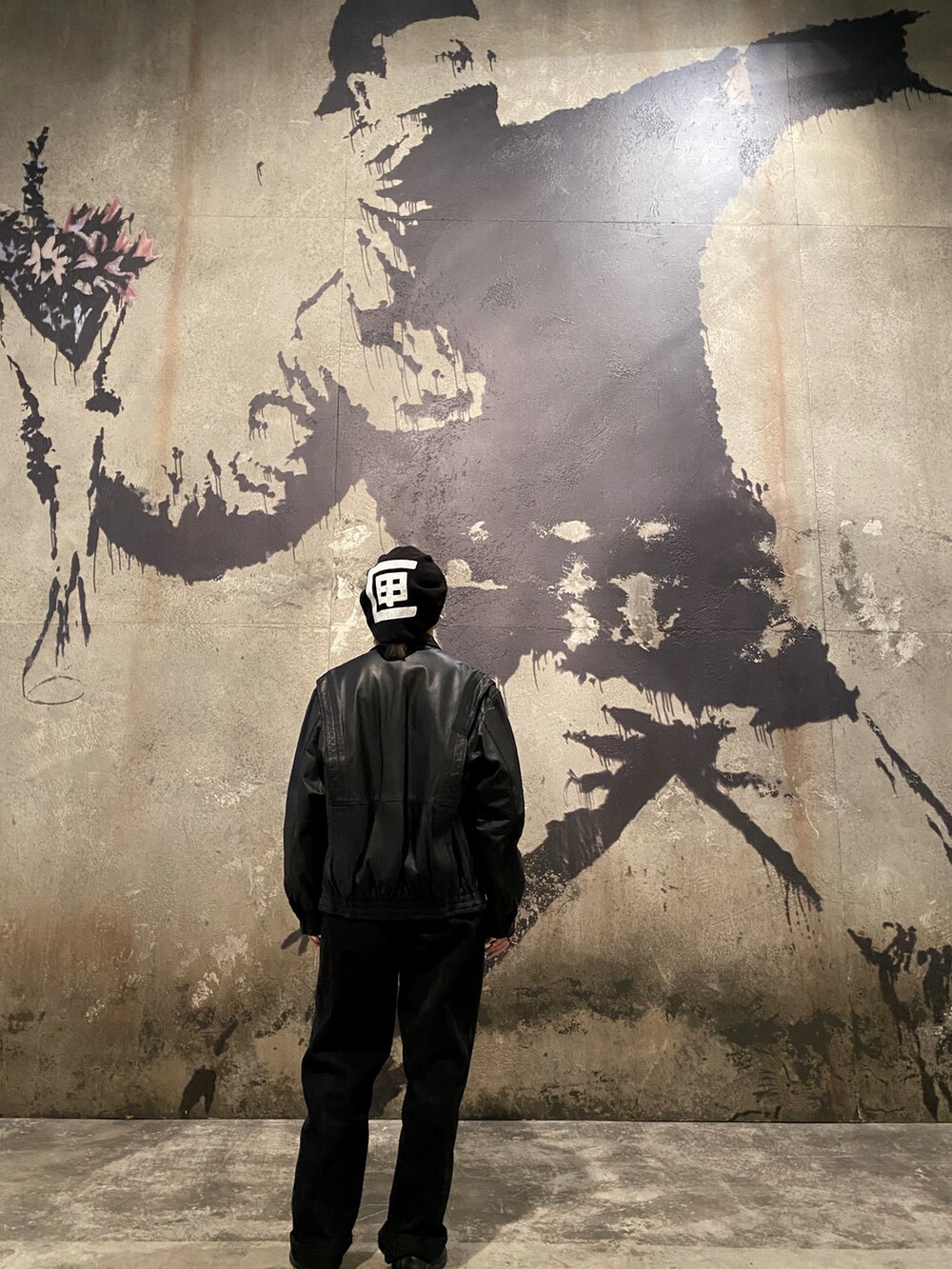 ブラック系のデニムパンツ、ブラック系のライダースジャケット、ブラック系のハンチング/ベレー帽を着用したレディースの秋コーディネートの2枚目の写真