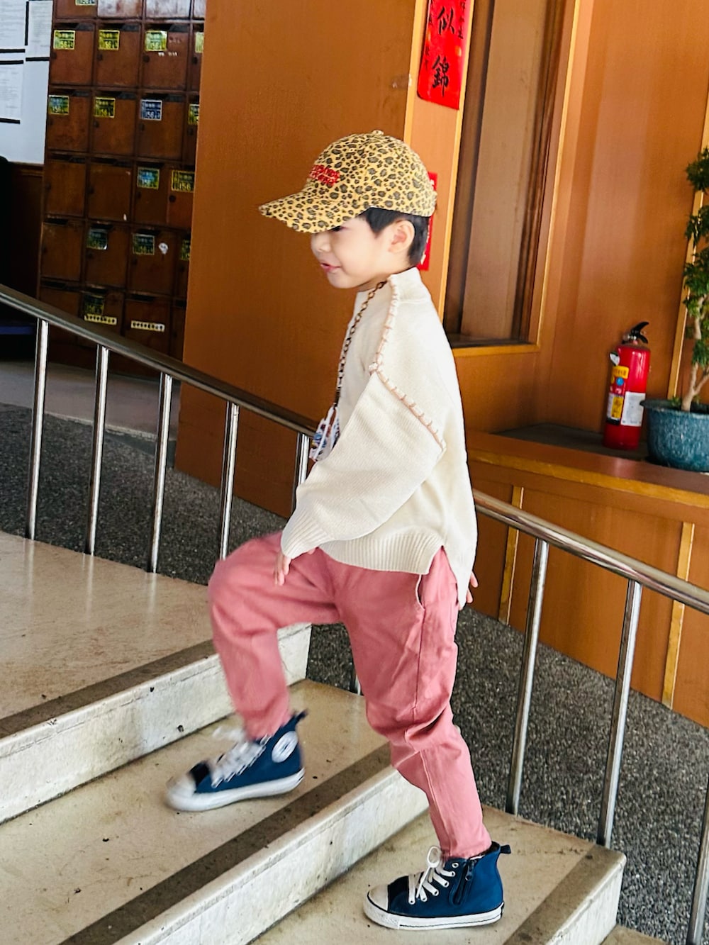 ブルー系のニット/セーター、ピンク系のチノパンツ、ブルー系のスニーカーを着用したキッズの冬コーディネートの2枚目の写真