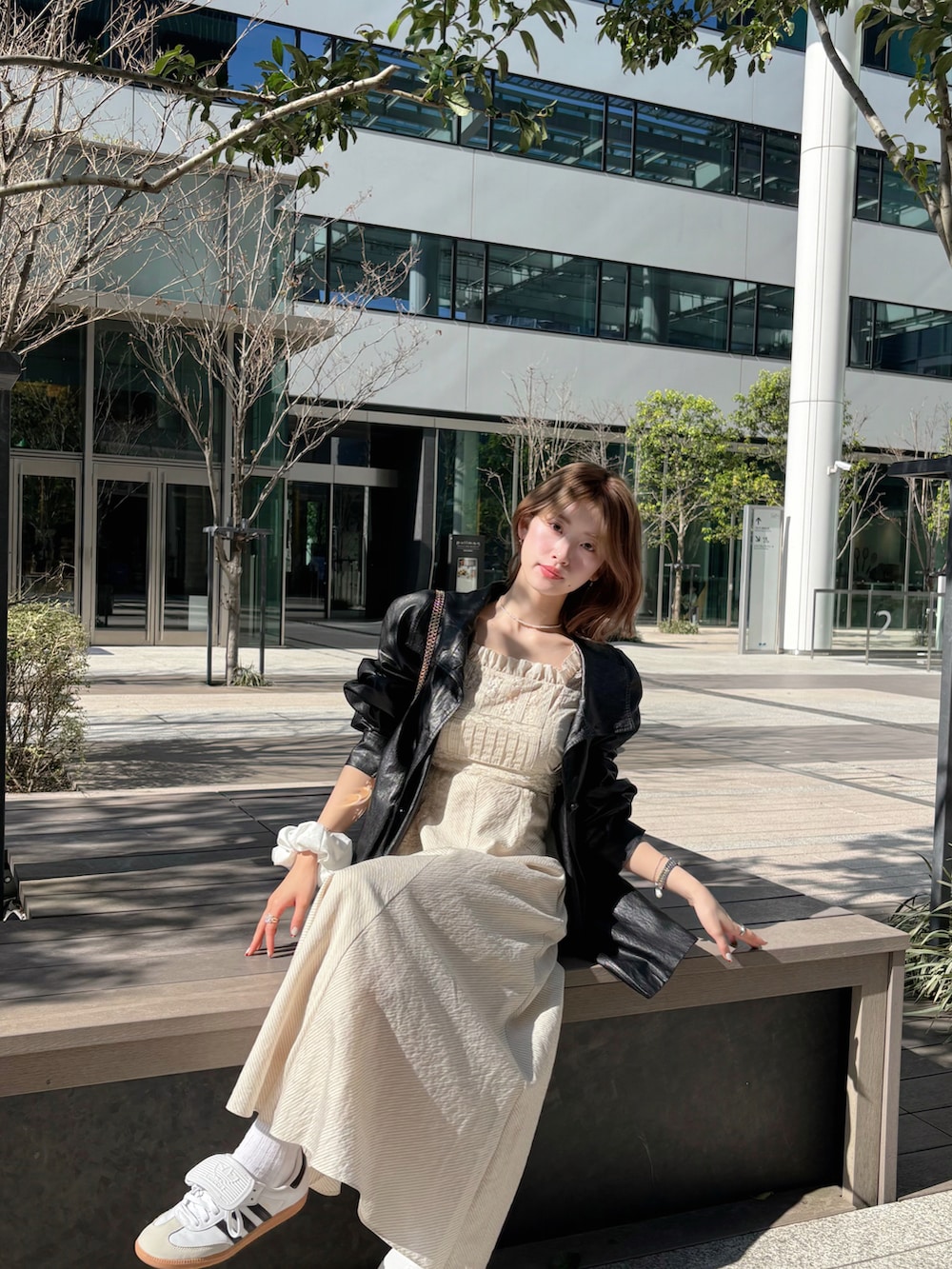 ホワイト系のスニーカー、ブラック系のジャケット/アウター、ホワイト系のワンピース/ドレスを着用したレディースの春コーディネートの2枚目の写真