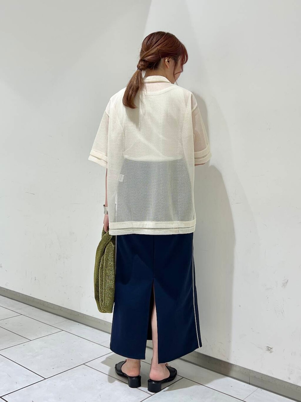 ブラック系のサンダル、ゴールド系のトートバッグ、ブルー系のスカートを着用したレディースの夏コーディネートの2枚目の写真