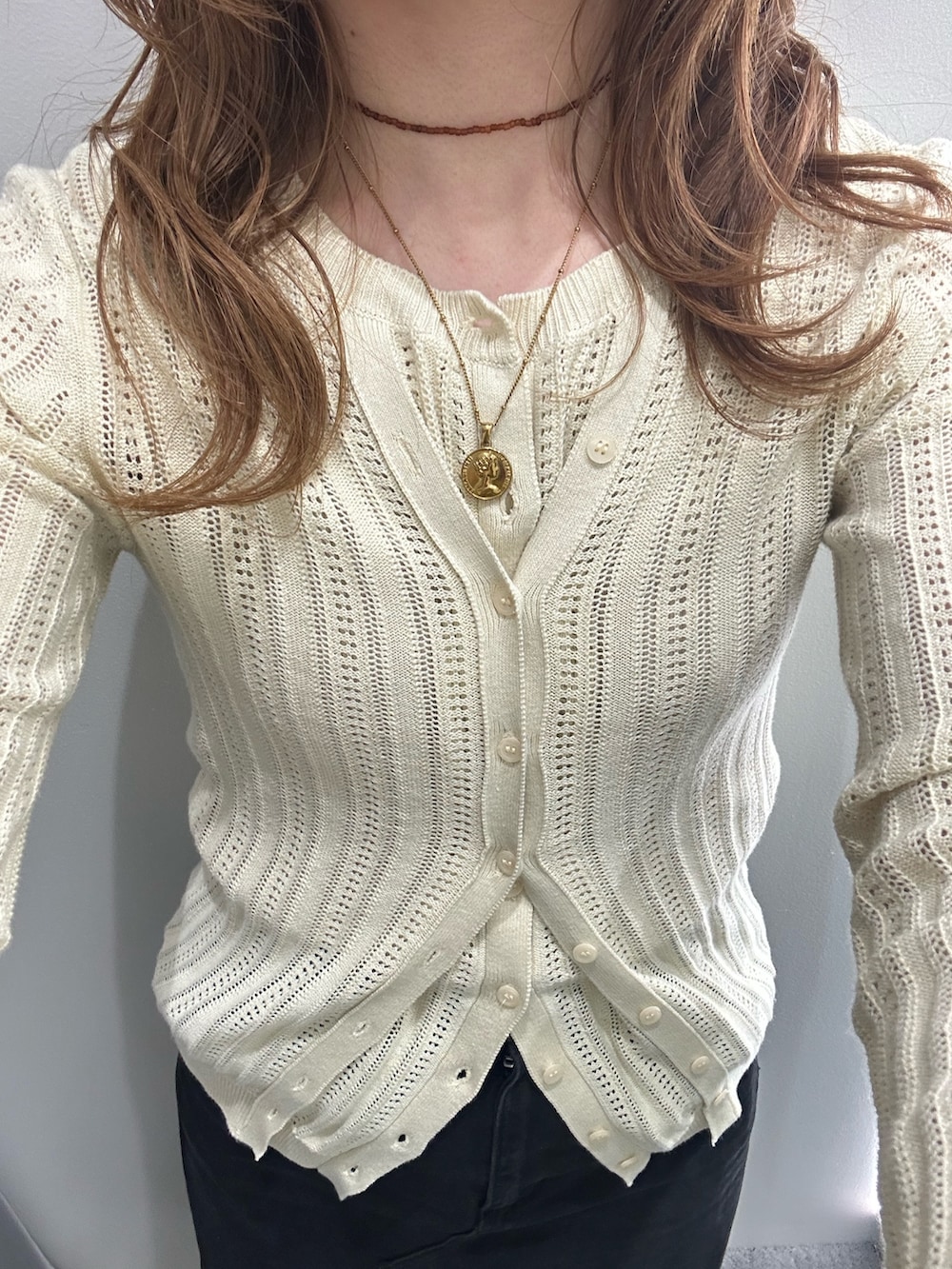 ホワイト系のニット/セーター、ベージュ系のローファー、ブラック系のスカートを着用したレディースの春コーディネートの3枚目の写真