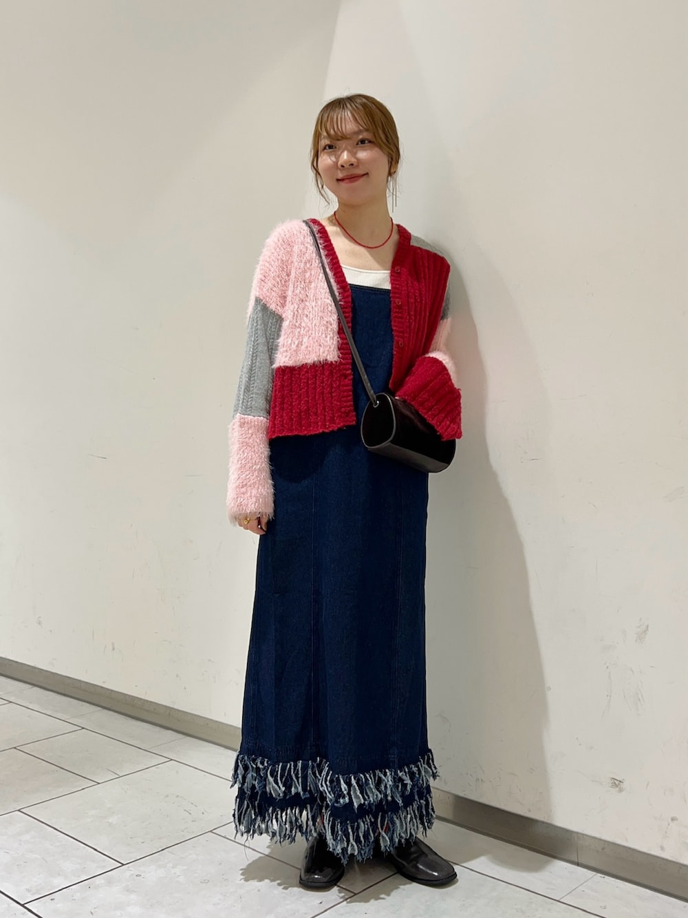 レッド系のカーディガン/ボレロ、ブラウン系のショルダーバッグ、ブルー系のワンピースを着用したレディースの秋コーディネートの2枚目の写真