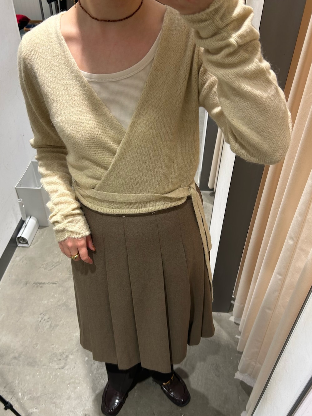 ブラウン系のスカート、ベージュ系のニット/セーター、ブラウン系のその他パンツを着用したレディースの秋コーディネートの4枚目の写真