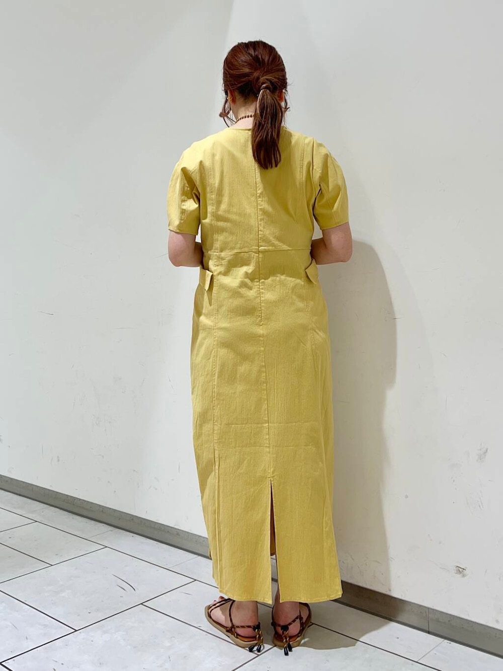 イエロー系のワンピース、ブラウン系のサンダルを着用したレディースの夏コーディネートの3枚目の写真