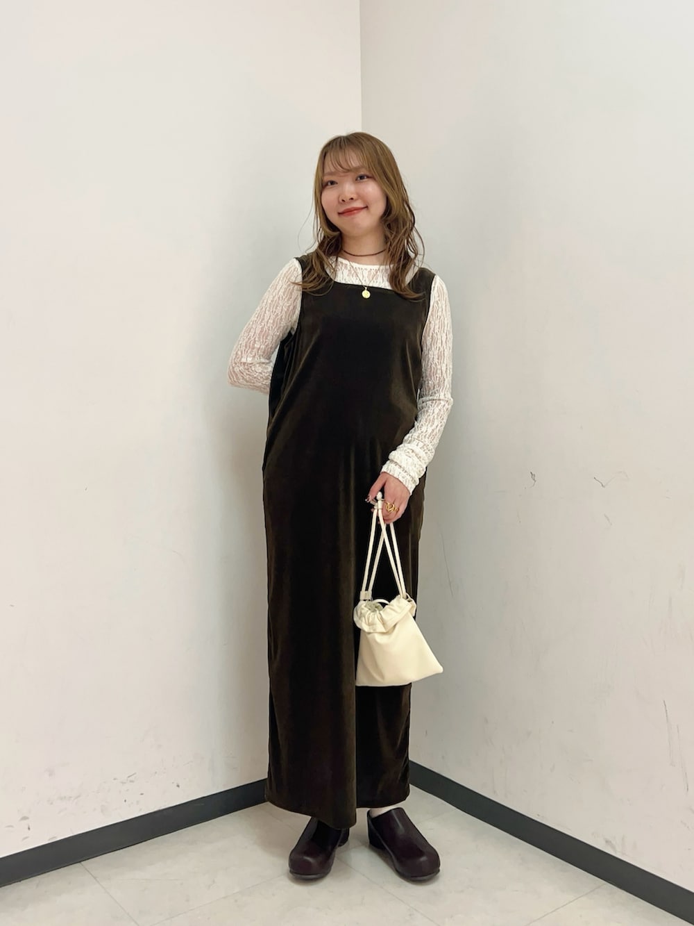 ブラウン系のワンピース、ホワイト系のショルダーバッグ、ホワイト系のTシャツ/カットソーを着用したレディースの春コーディネートの2枚目の写真