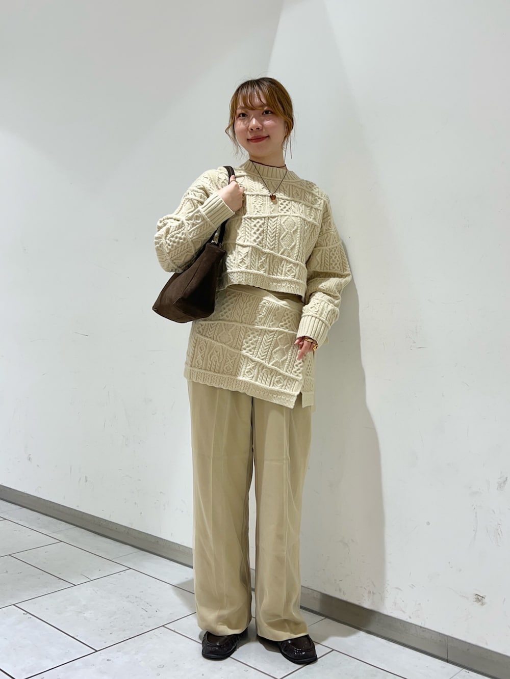 ベージュ系のニット/セーター、ベージュ系のスカート、ベージュ系のその他パンツを着用したレディースの冬コーディネートの2枚目の写真