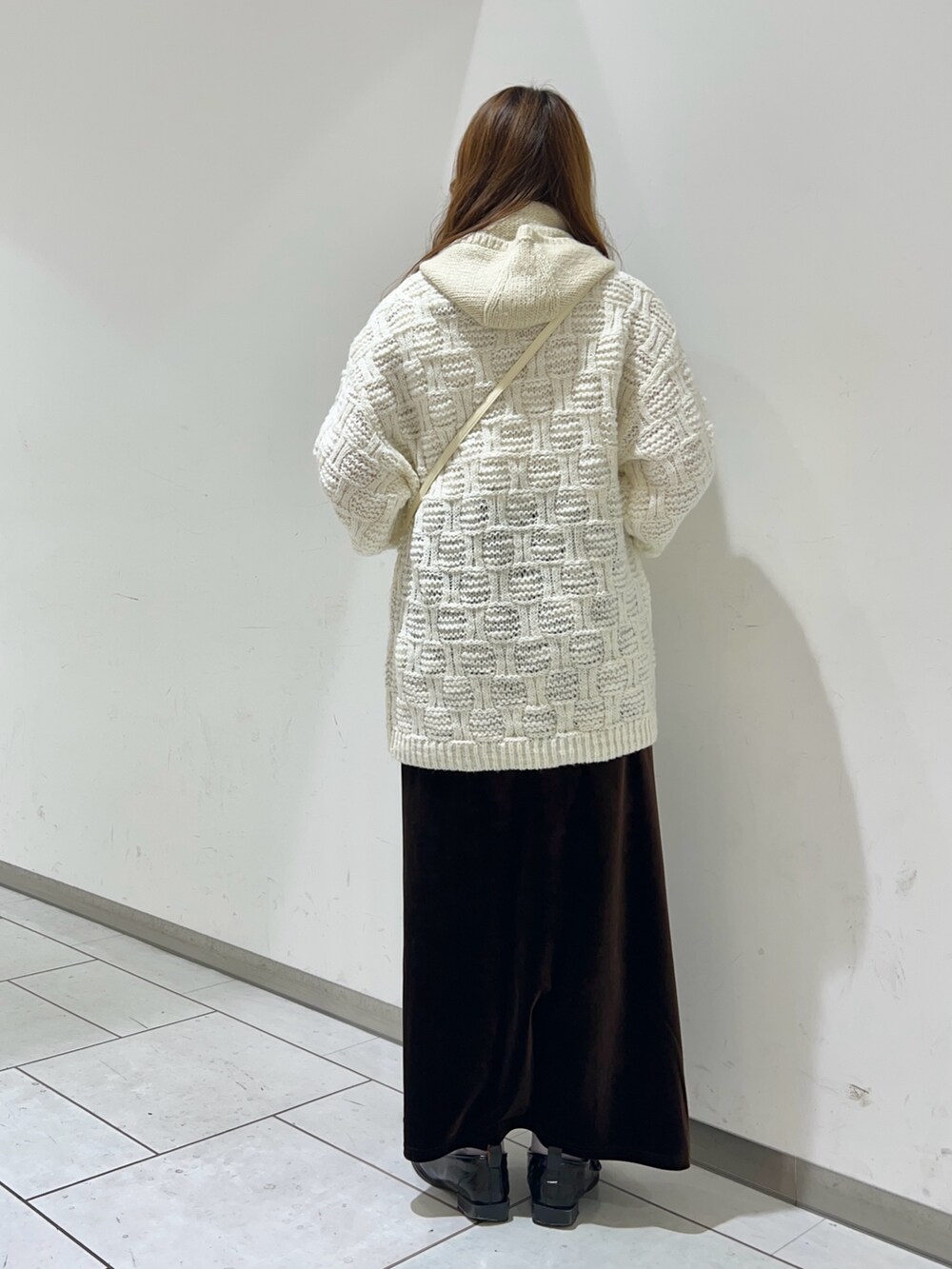 ホワイト系のニット/セーター、ホワイト系のショルダーバッグ、ブラウン系のスカートを着用したレディースの秋コーディネートの4枚目の写真