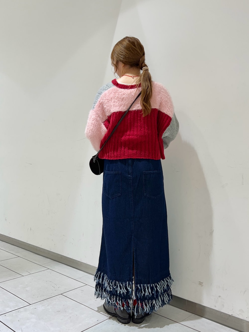 レッド系のカーディガン/ボレロ、ブラウン系のショルダーバッグ、ブルー系のワンピースを着用したレディースの秋コーディネートの3枚目の写真