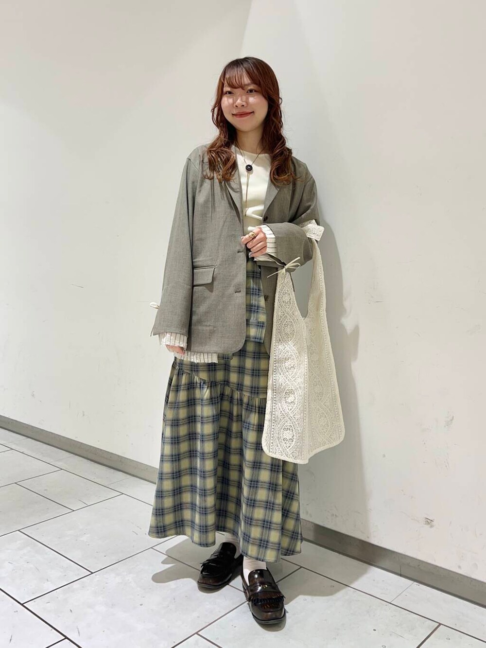 ベージュ系のその他アウター、ベージュ系のスカート、ホワイト系のTシャツ/カットソーを着用したレディースの冬コーディネートの2枚目の写真
