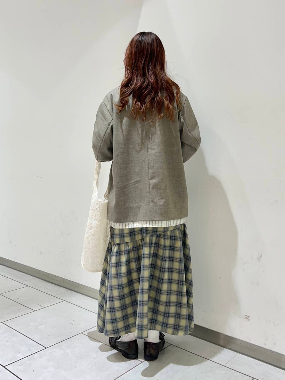 ベージュ系のその他アウター、ベージュ系のスカート、ホワイト系のTシャツ/カットソーを着用したレディースの冬コーディネートの3枚目の写真