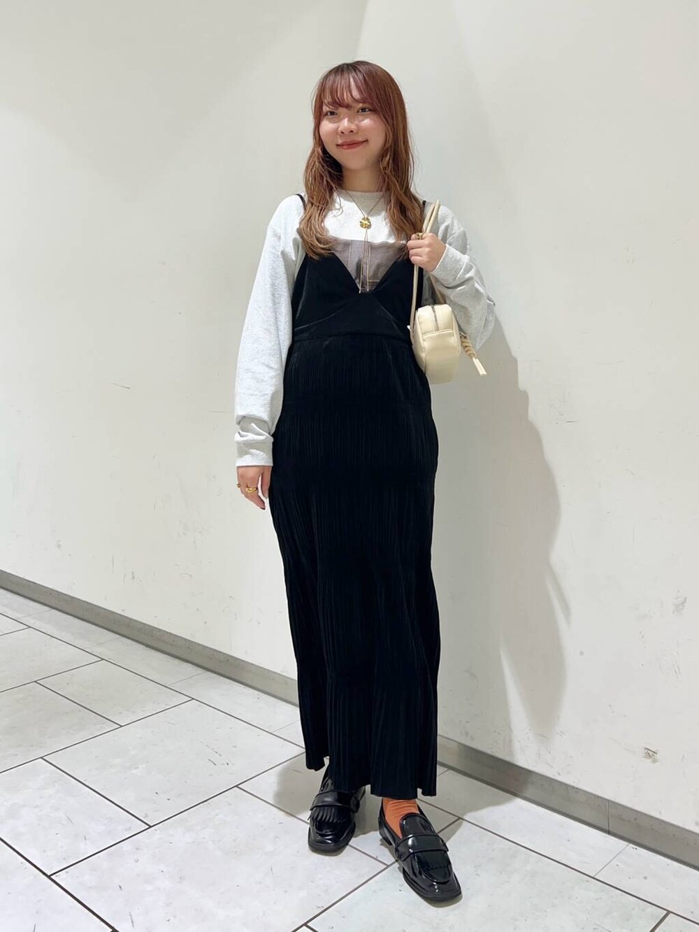 グレー系のTシャツ/カットソー、ブラック系のローファー、ブラック系のワンピースを着用したレディースの秋コーディネートの2枚目の写真