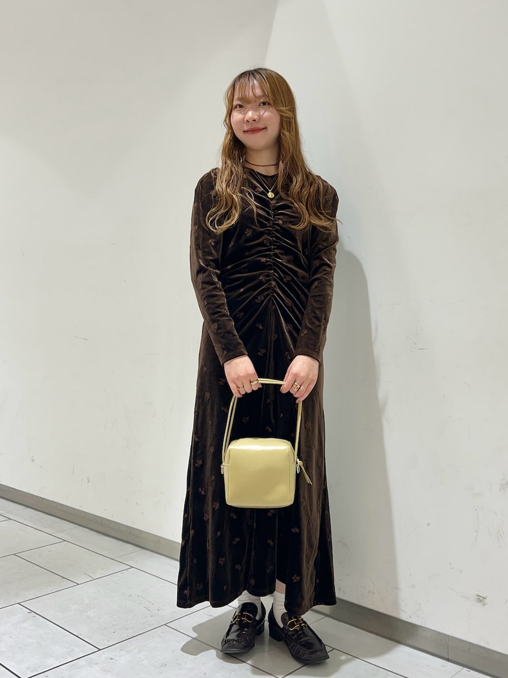 ブラウン系のワンピース、ベージュ系のショルダーバッグを着用したレディースの冬コーディネートの2枚目の写真