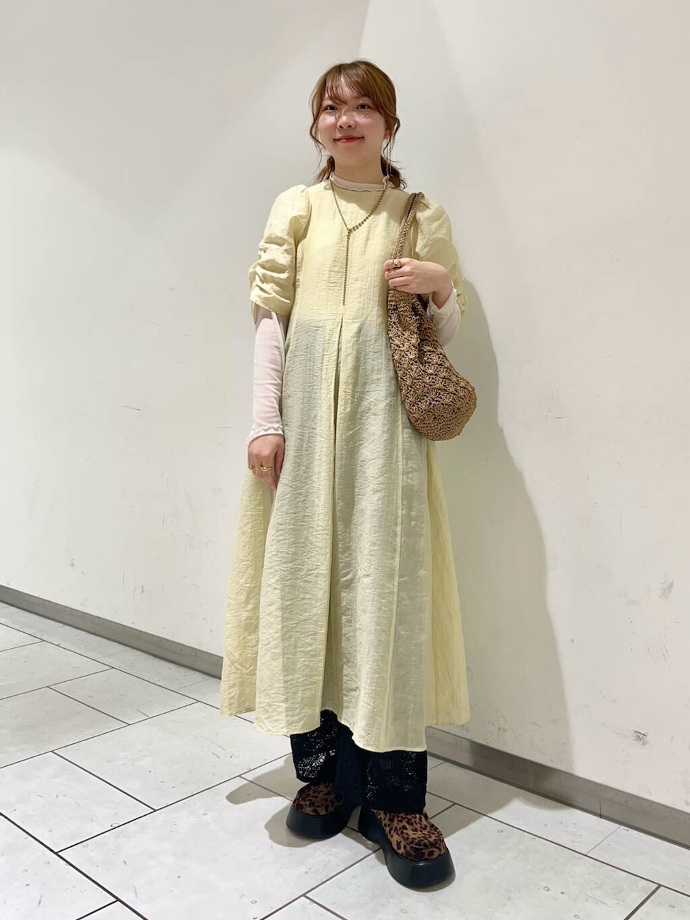 ベージュ系のトートバッグ、ブラック系のその他パンツ、イエロー系のワンピースを着用したレディースの春コーディネートの2枚目の写真