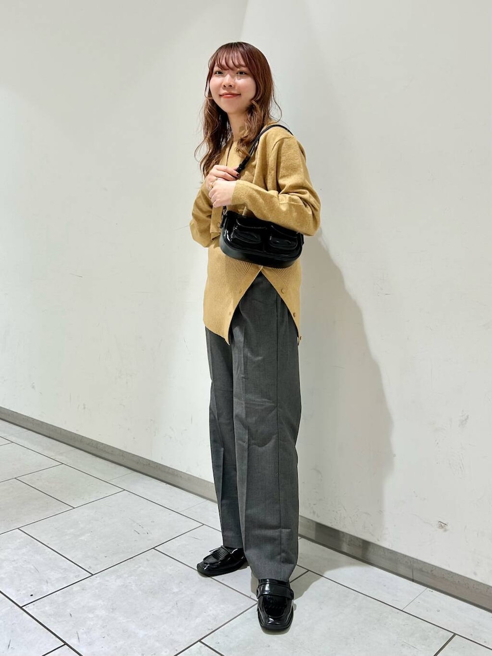 グレー系のその他パンツ、ブラック系のローファー、ベージュ系のカーディガン/ボレロを着用したレディースの秋コーディネートの2枚目の写真