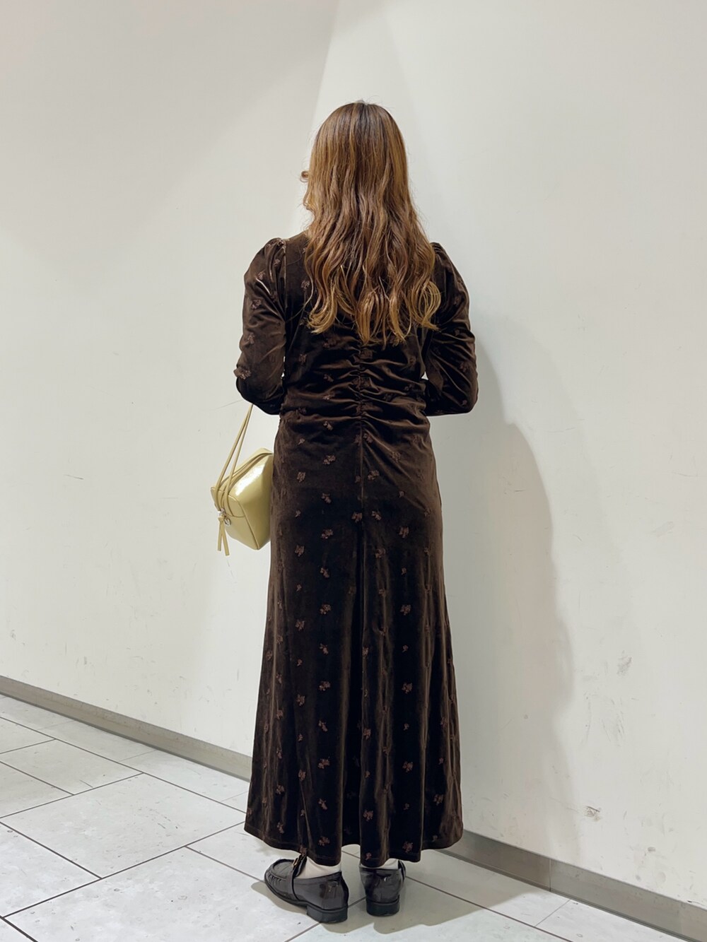 ブラウン系のワンピース、ベージュ系のショルダーバッグを着用したレディースの冬コーディネートの3枚目の写真