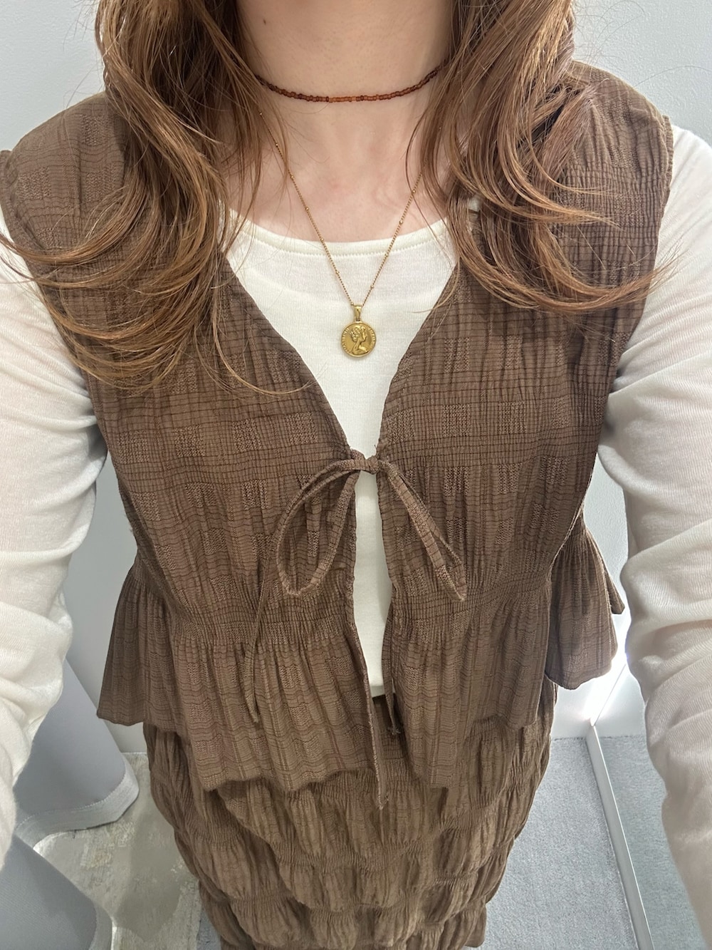 ブラウン系のセットアップ、ホワイト系のTシャツ/カットソー、ホワイト系のショルダーバッグを着用したレディースの春コーディネートの3枚目の写真