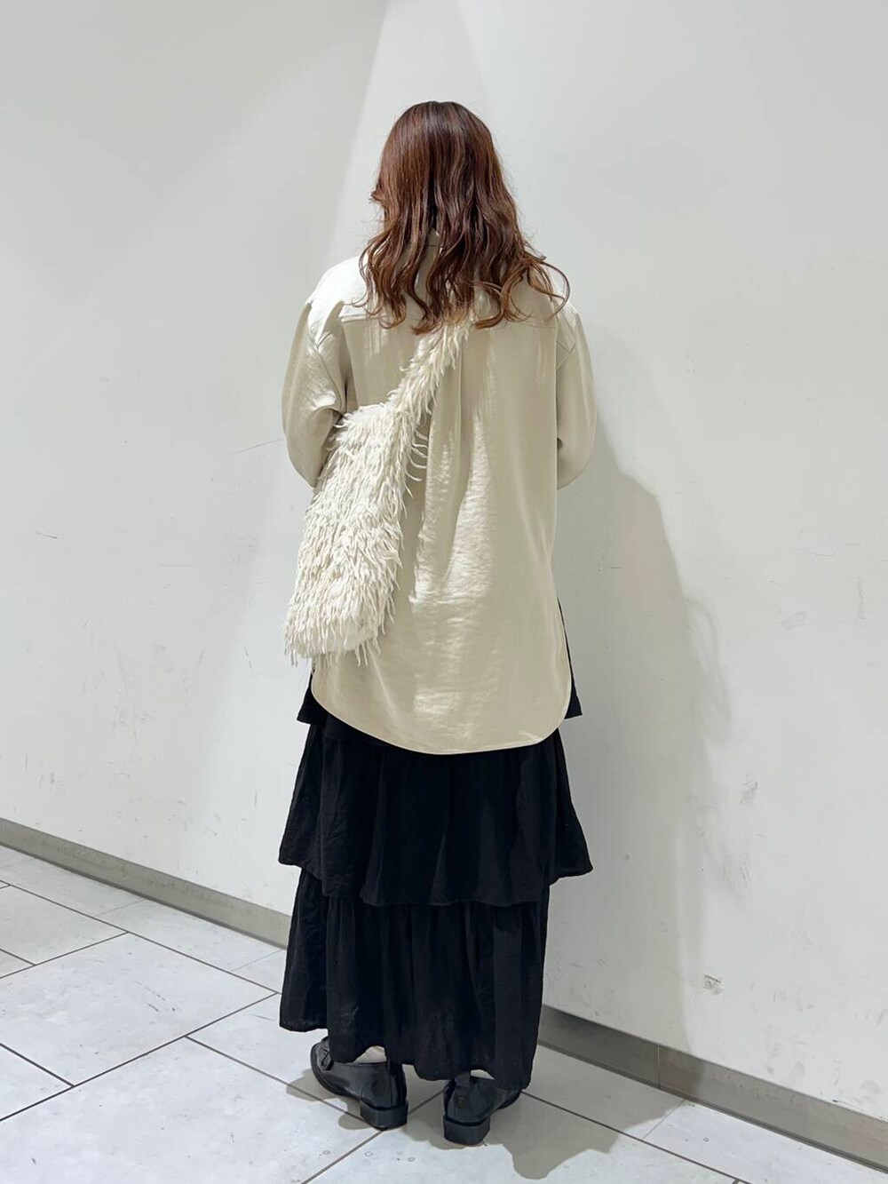 ホワイト系のショルダーバッグ、ブラック系のローファー、ベージュ系のシャツ/ブラウスを着用したレディースの冬コーディネートの3枚目の写真