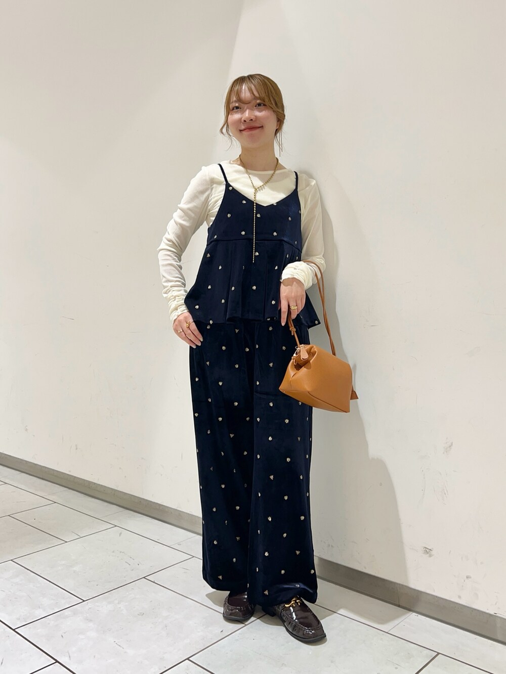 イエロー系のショルダーバッグ、ホワイト系のTシャツ/カットソー、ブルー系のキャミソールを着用したレディースの秋コーディネートの2枚目の写真