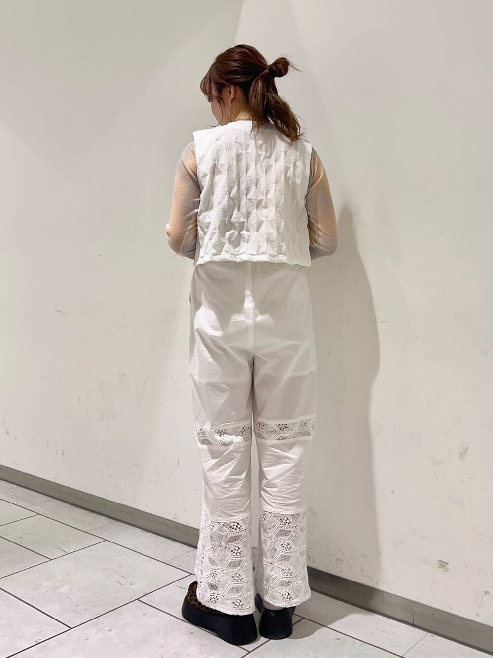 ホワイト系のベスト、ホワイト系のその他パンツ、オレンジ系のニット/セーターを着用したレディースの春コーディネートの2枚目の写真