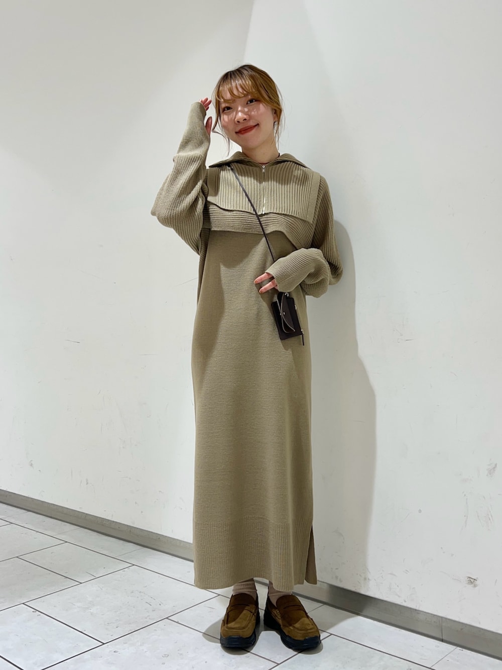 ベージュ系のワンピース、ブラウン系のショルダーバッグ、ブラウン系のその他シューズを着用したレディースの冬コーディネートの2枚目の写真