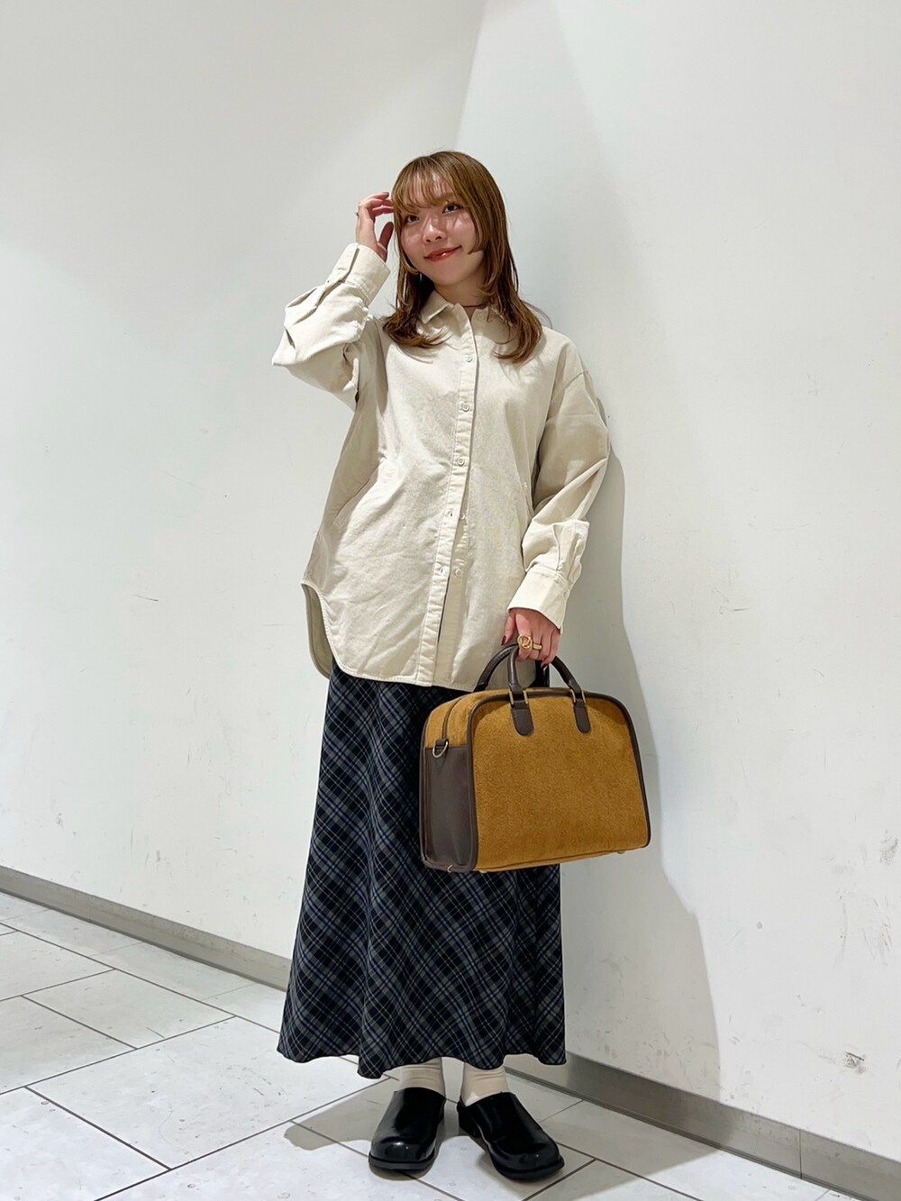 ホワイト系のシャツ/ブラウス、イエロー系のボストンバッグ、グレー系のスカートを着用したレディースの冬コーディネートの3枚目の写真