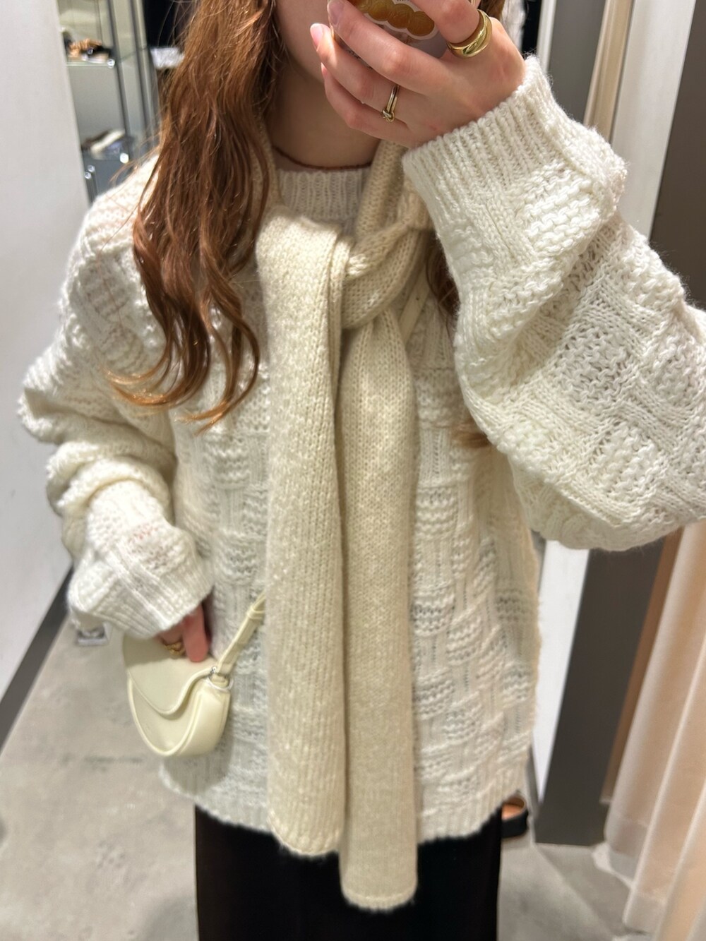 ホワイト系のニット/セーター、ホワイト系のショルダーバッグ、ブラウン系のスカートを着用したレディースの秋コーディネートの5枚目の写真