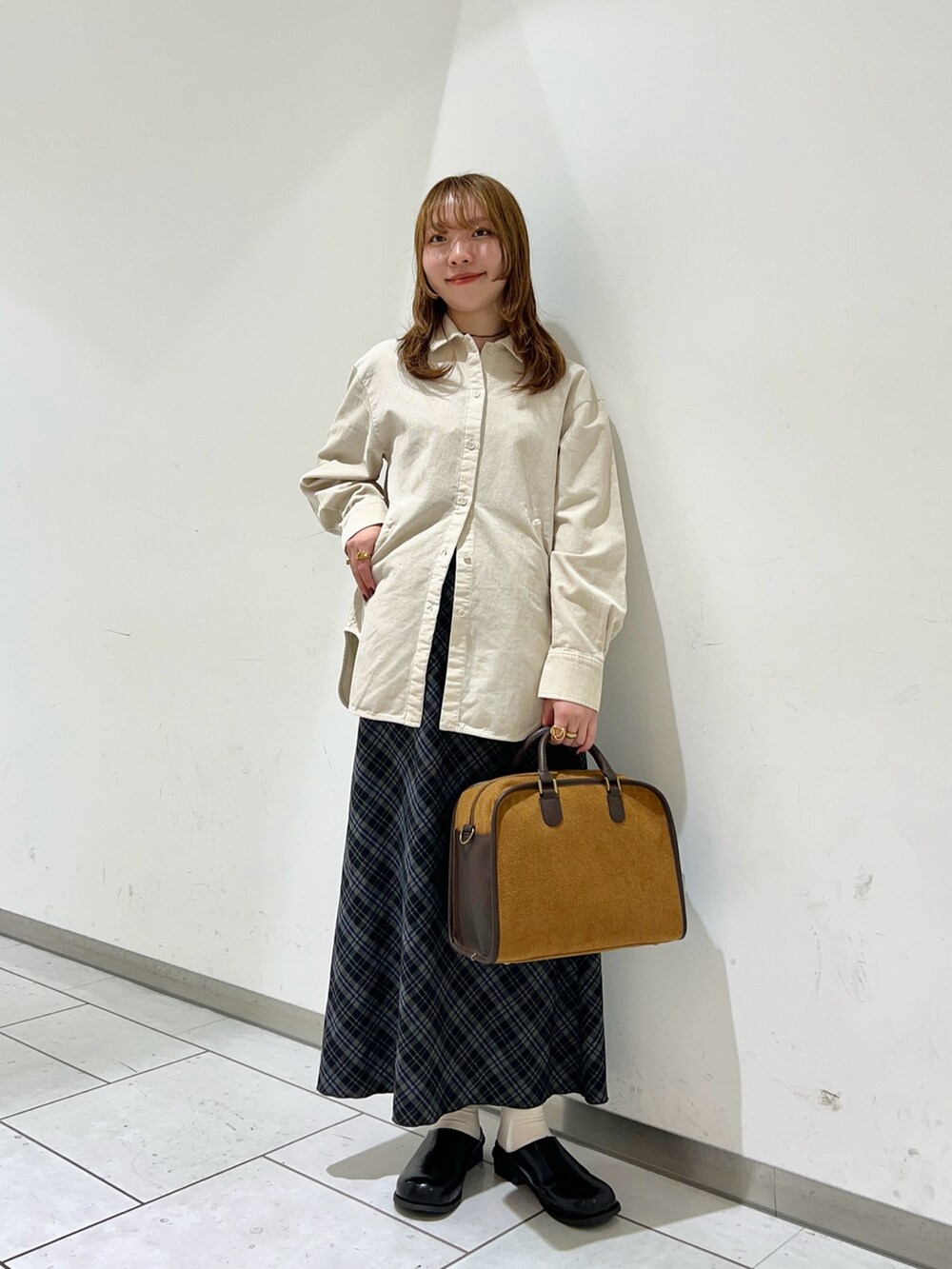 ホワイト系のシャツ/ブラウス、イエロー系のボストンバッグ、グレー系のスカートを着用したレディースの冬コーディネートの2枚目の写真