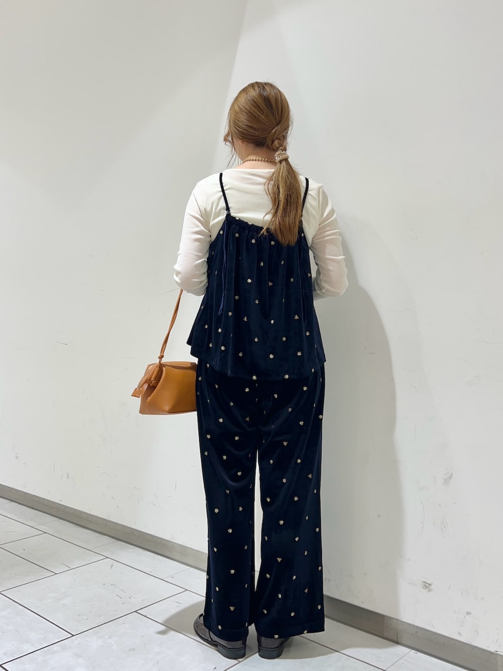 イエロー系のショルダーバッグ、ホワイト系のTシャツ/カットソー、ブルー系のキャミソールを着用したレディースの秋コーディネートの3枚目の写真