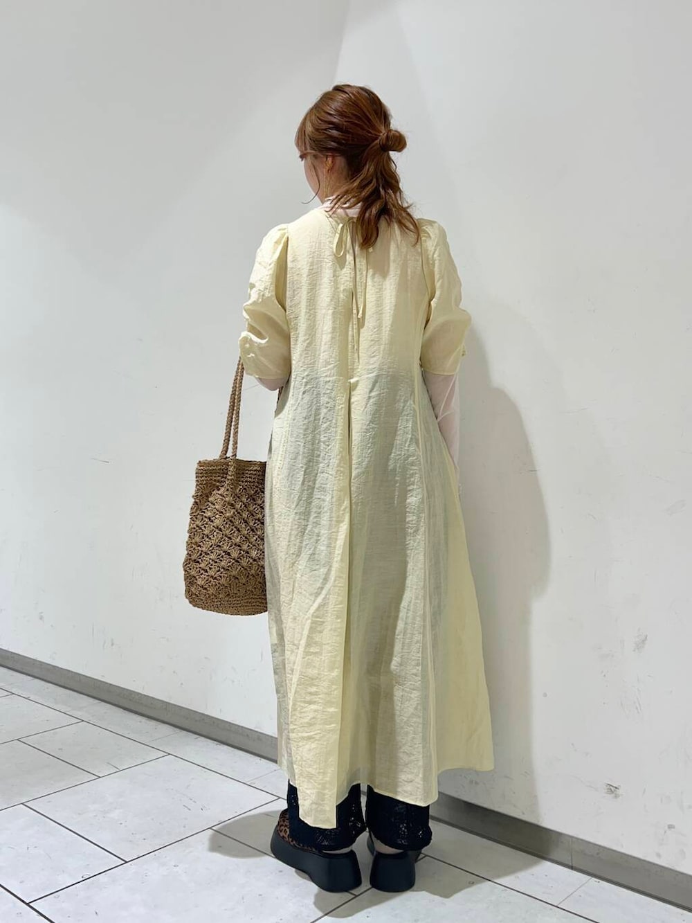 ベージュ系のトートバッグ、ブラック系のその他パンツ、イエロー系のワンピースを着用したレディースの春コーディネートの3枚目の写真