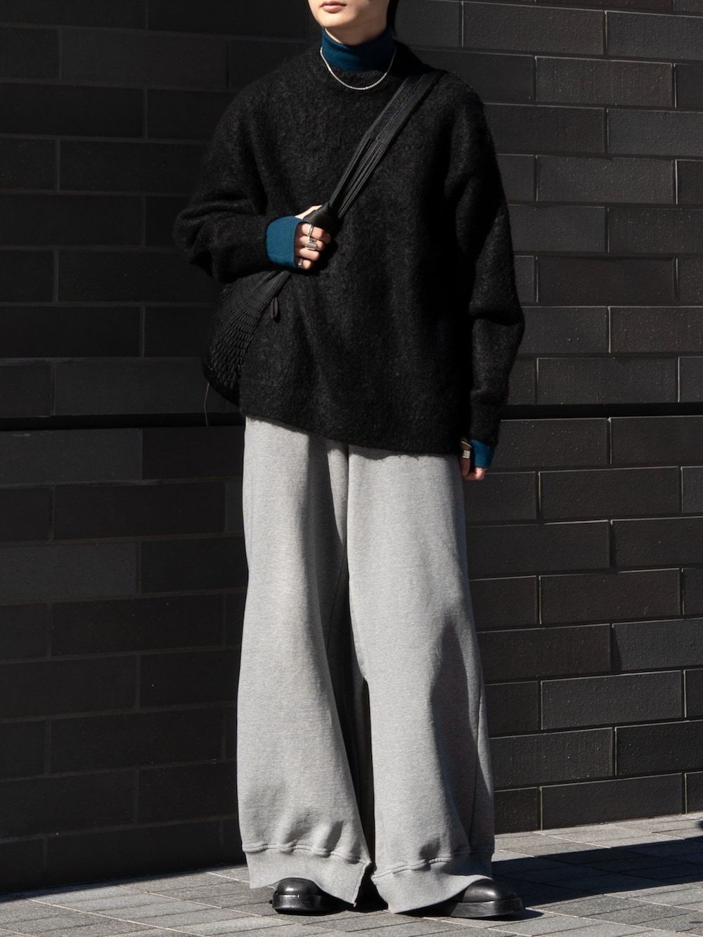ブラック系のニット/セーター、ブルー系のニット/セーター、ブラック系のショルダーバッグを着用したメンズの冬コーディネートの3枚目の写真