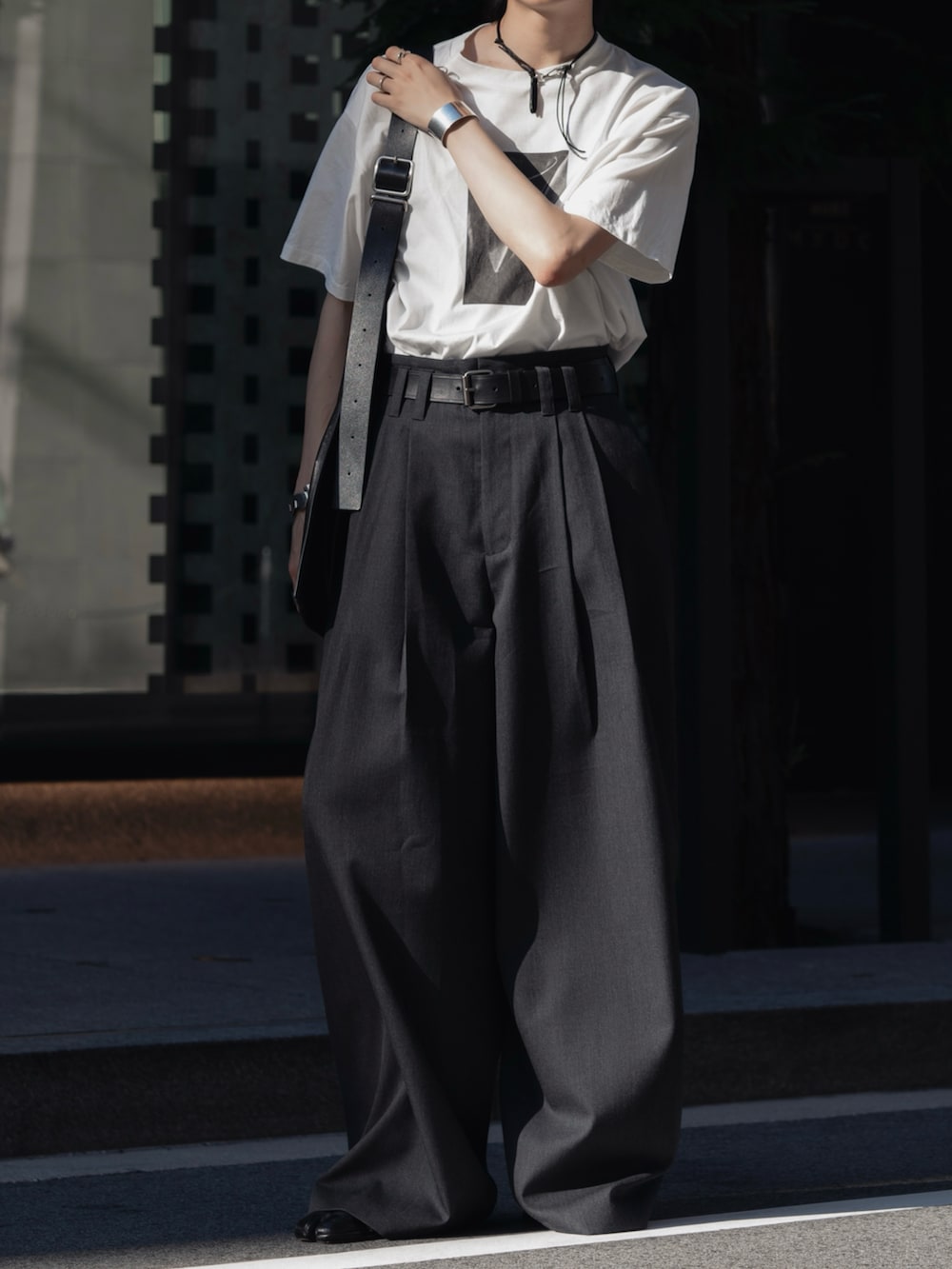 ホワイト系のTシャツ/カットソー、グレー系のパンツ、ブラック系のドレスシューズを着用したメンズの夏コーディネートの2枚目の写真