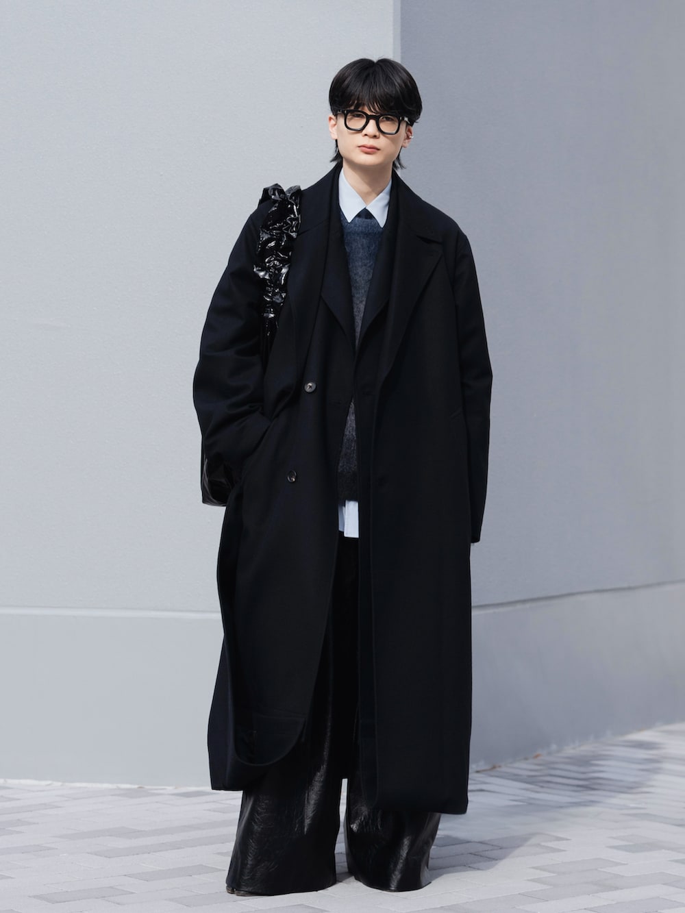 ブラック系のブーツ、ブラック系のスラックス、ブラック系のショルダーバッグを着用したメンズの冬コーディネートの2枚目の写真