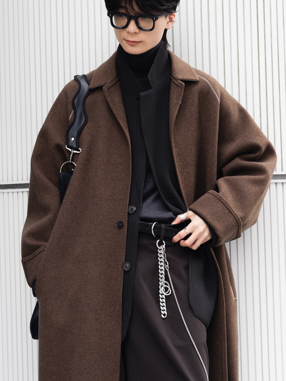 ブラック系のニット/セーター、ブラック系のブーツ、グレー系のテーラードジャケットを着用したメンズの冬コーディネートの3枚目の写真