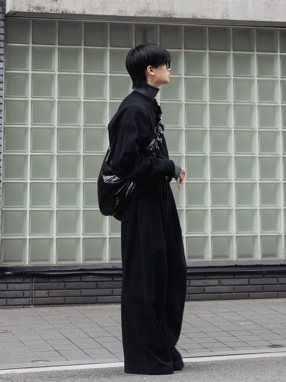 ブラック系のスウェット、ブラック系のスウェットパンツ、グレー系のニット/セーターを着用したメンズの秋コーディネートの2枚目の写真