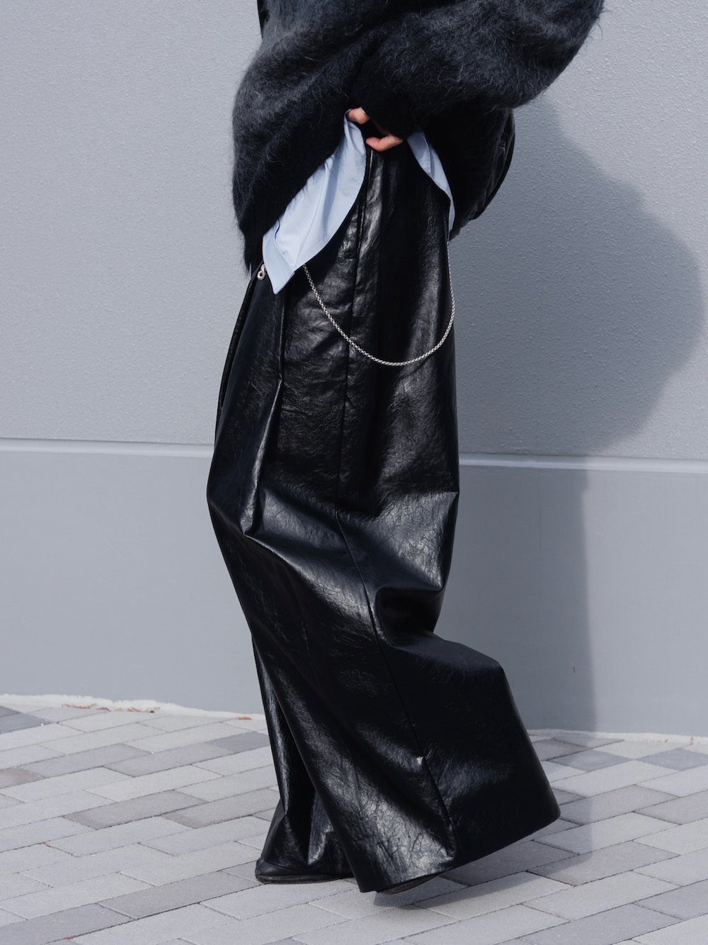 ブラック系のブーツ、ブラック系のスラックス、ブラック系のショルダーバッグを着用したメンズの冬コーディネートの4枚目の写真