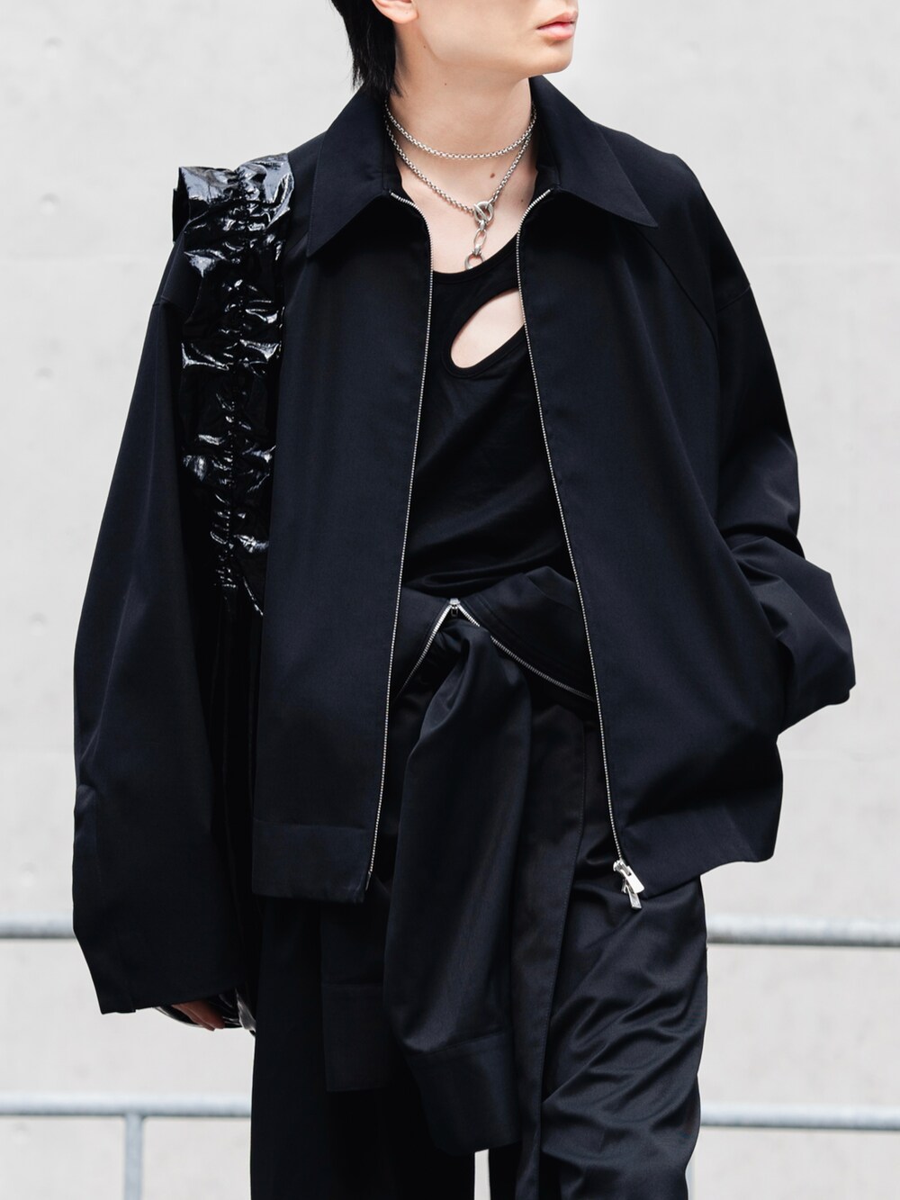 ブラック系のつなぎ/オールインワン、ブラック系のブルゾン、ブラック系のショルダーバッグを着用したメンズの春コーディネートの2枚目の写真