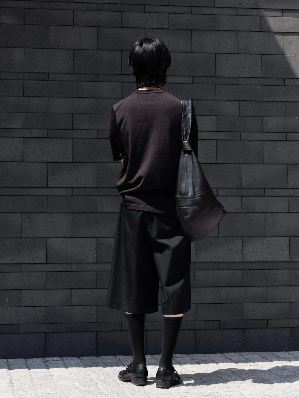 ブラック系のその他パンツ、ブラック系のドレスシューズ、ブラック系のショルダーバッグを着用したメンズの春コーディネートの3枚目の写真