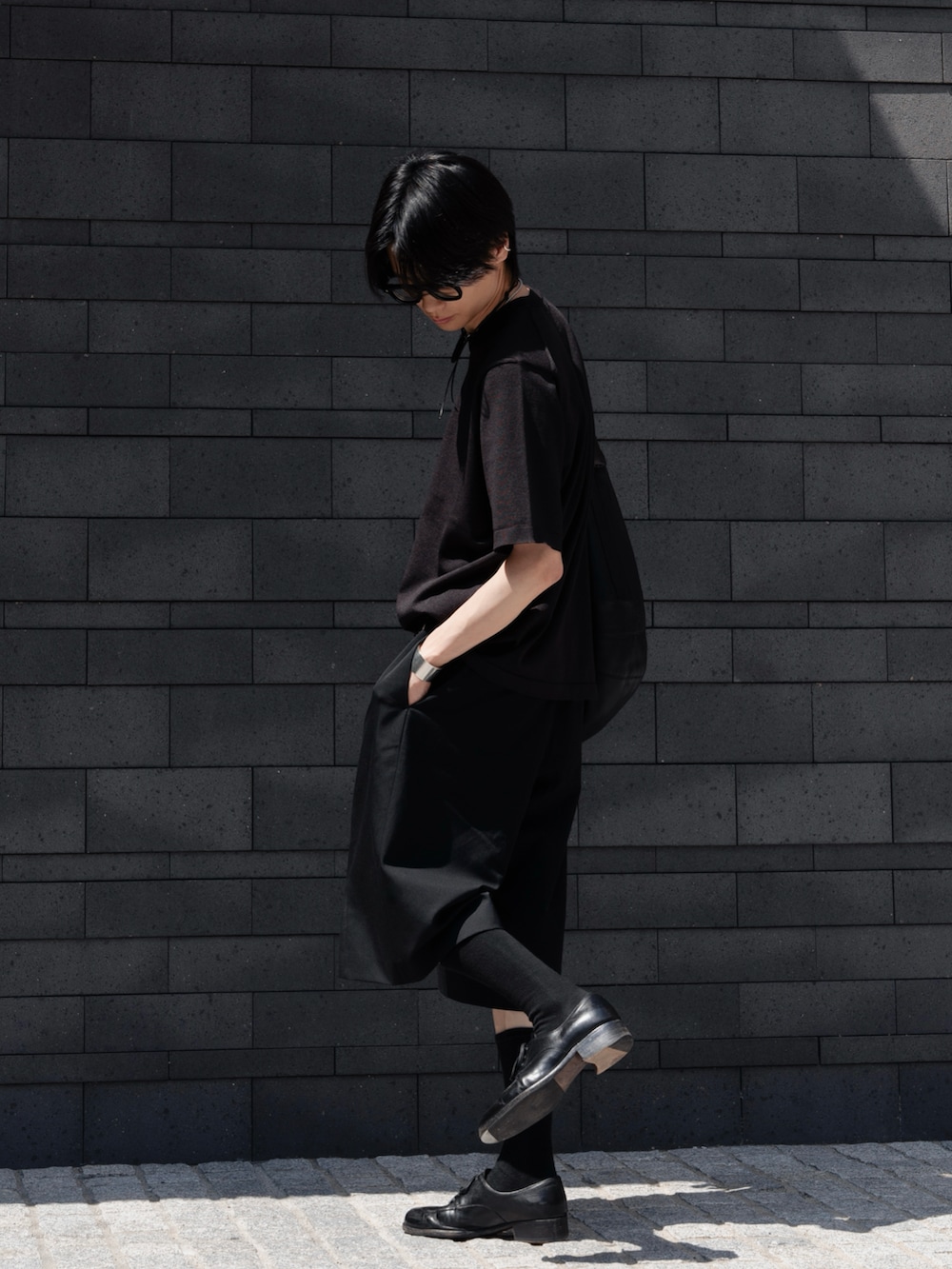 ブラック系のその他パンツ、ブラック系のドレスシューズ、ブラック系のショルダーバッグを着用したメンズの春コーディネートの2枚目の写真