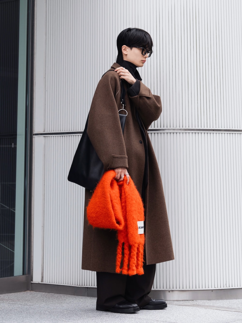 ブラック系のニット/セーター、ブラック系のブーツ、グレー系のテーラードジャケットを着用したメンズの冬コーディネートの2枚目の写真