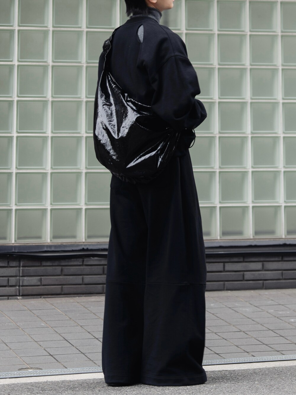 ブラック系のスウェット、ブラック系のスウェットパンツ、グレー系のニット/セーターを着用したメンズの秋コーディネートの3枚目の写真