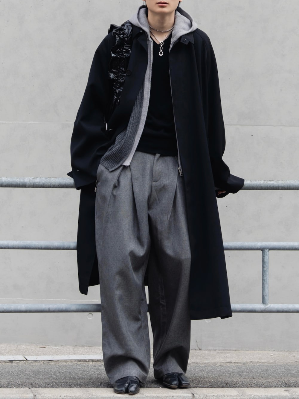 ブラック系のショルダーバッグ、ブラック系のニット/セーター、ブラック系のブーツを着用したメンズの冬コーディネートの2枚目の写真