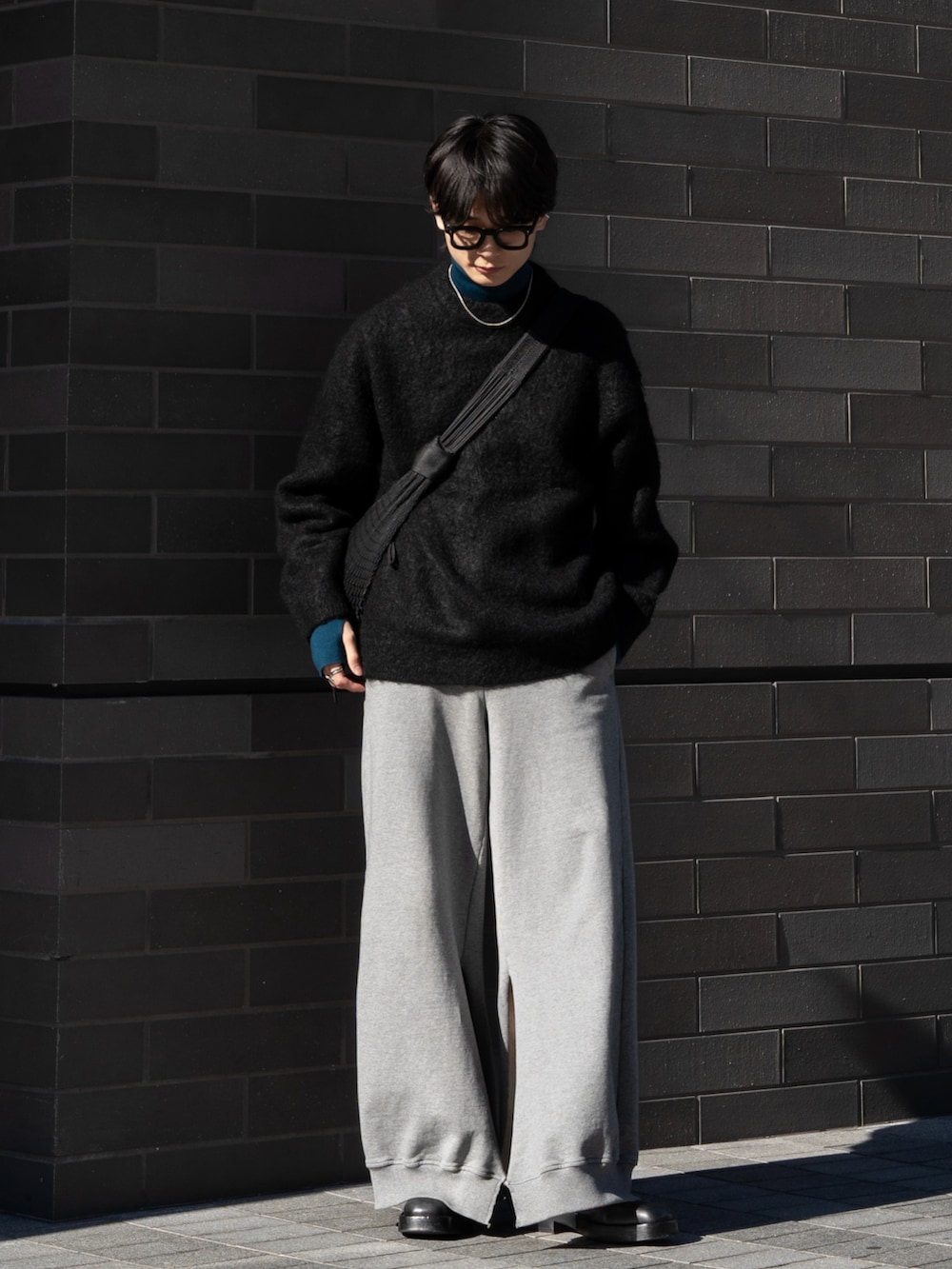 ブラック系のニット/セーター、ブルー系のニット/セーター、ブラック系のショルダーバッグを着用したメンズの冬コーディネートの2枚目の写真