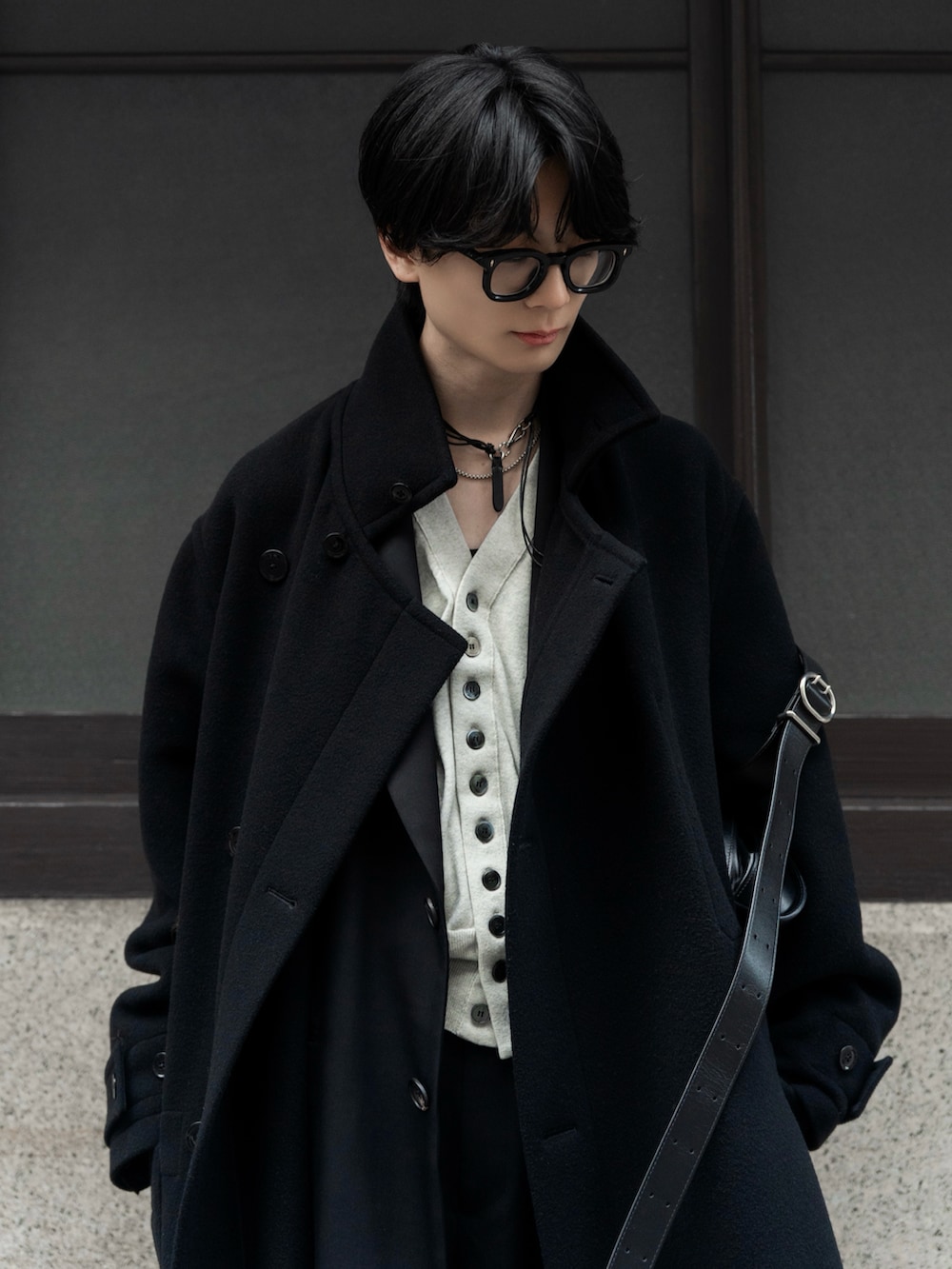 ブラック系のスラックス、ベージュ系のカーディガン/ボレロ、ブラック系のショルダーバッグを着用したメンズの冬コーディネートの2枚目の写真