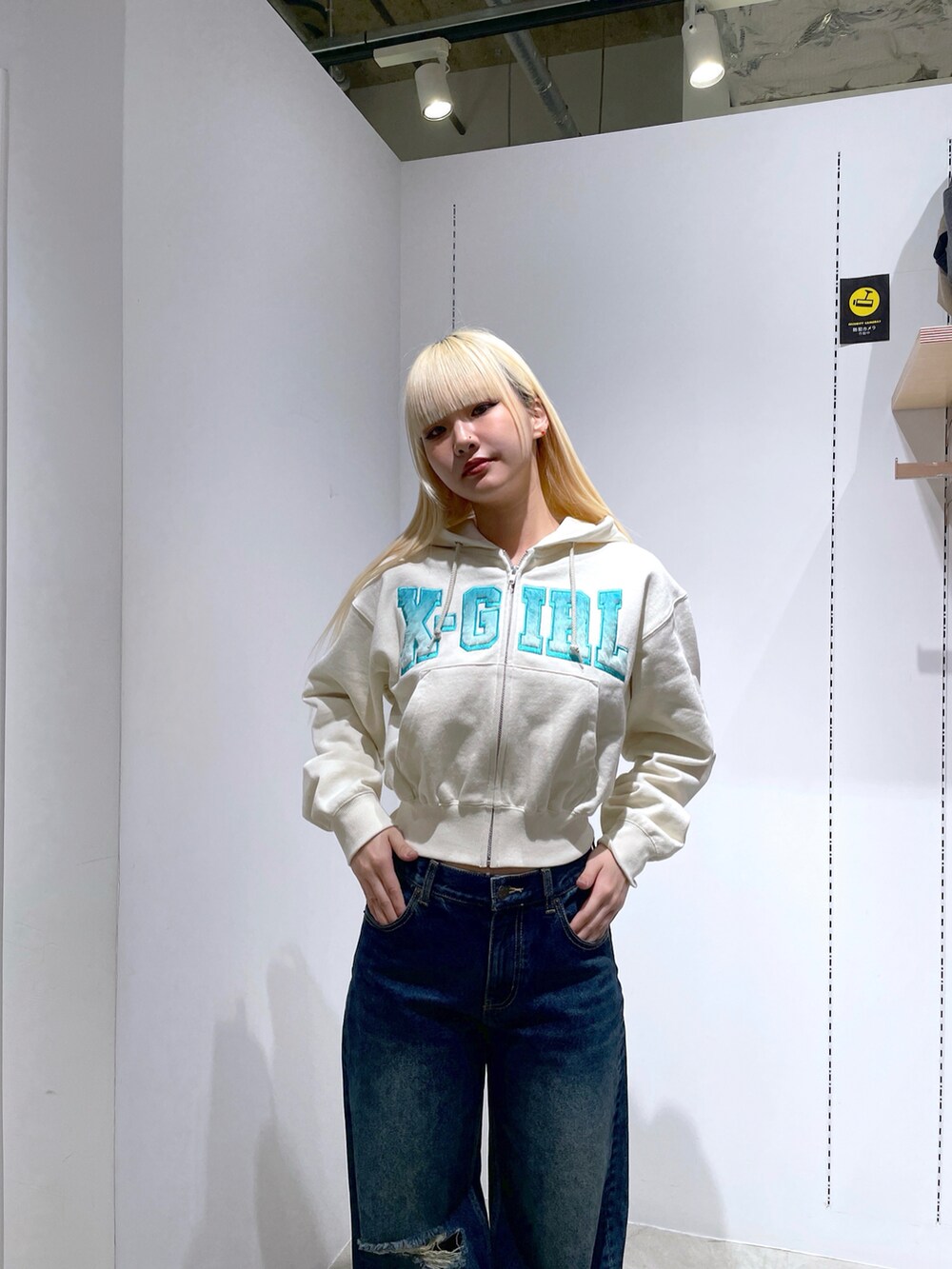 ホワイト系のパーカー、ブルー系のデニムパンツ、ブルー系のトートバッグを着用したレディースの冬コーディネートの4枚目の写真