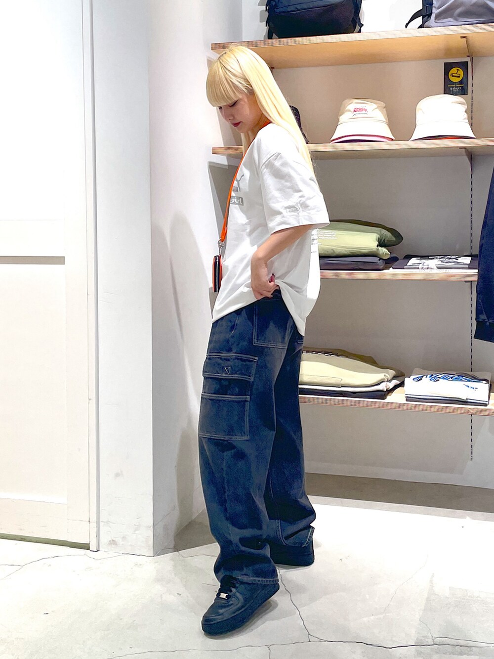 ホワイト系のTシャツ/カットソー、ブラック系のカーゴパンツ、オレンジ系のカードケースを着用したレディースの春コーディネートの3枚目の写真