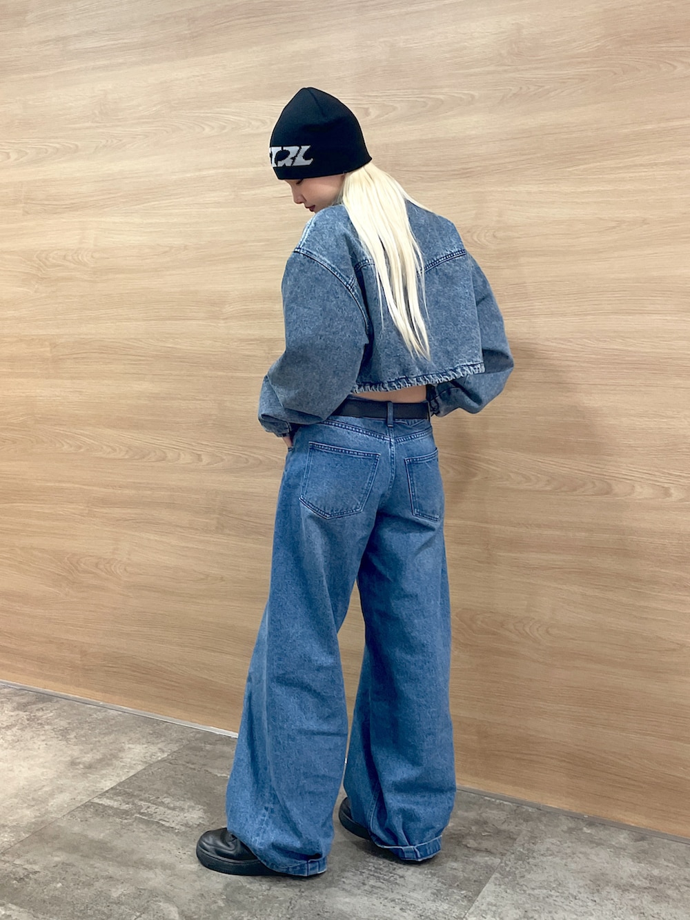 ブルー系のデニムジャケット、ブルー系のデニムパンツ、ブラック系のニットキャップ/ビーニーを着用したレディースの秋コーディネートの2枚目の写真