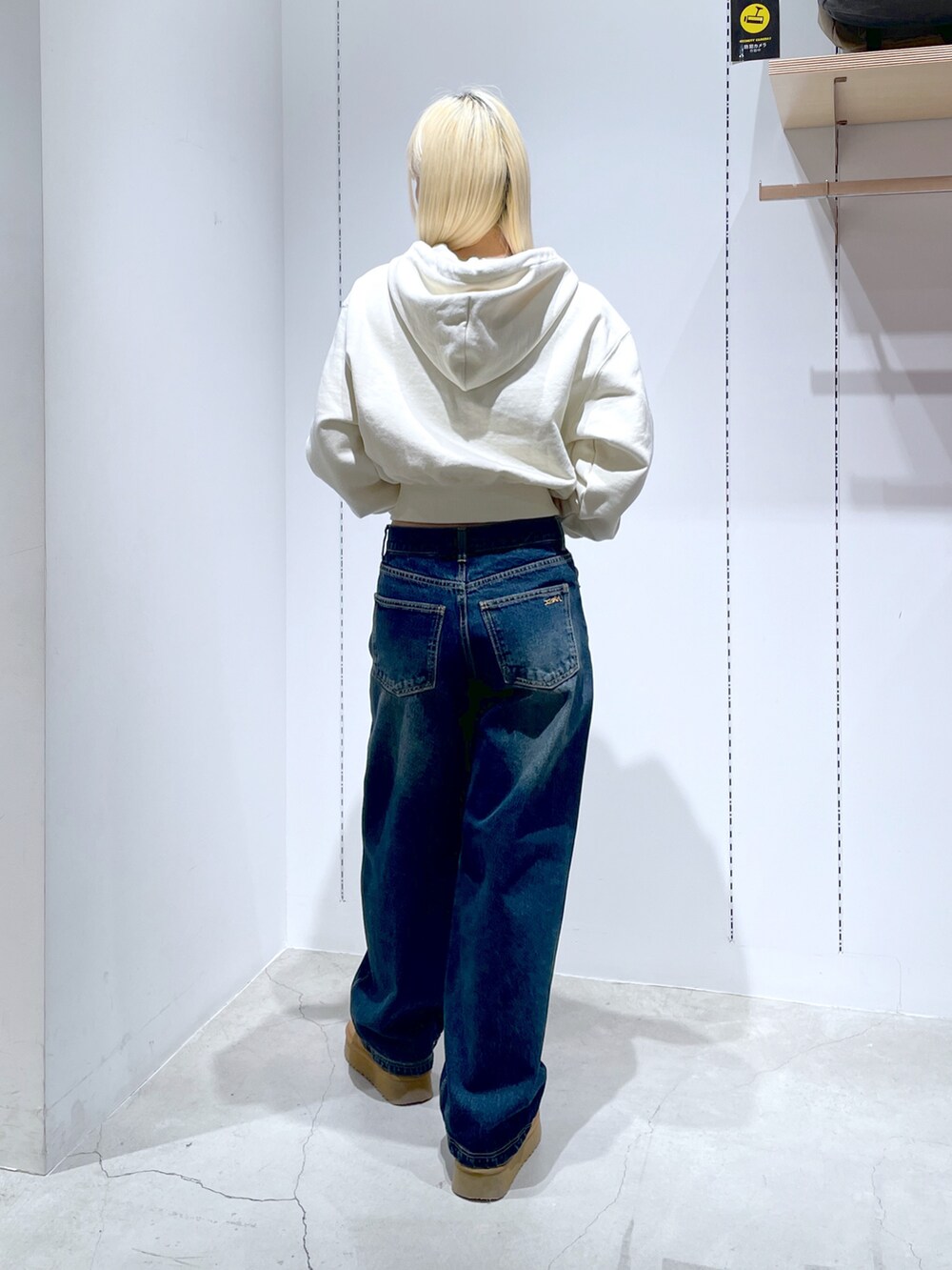 ホワイト系のパーカー、ブルー系のデニムパンツ、ブルー系のトートバッグを着用したレディースの冬コーディネートの3枚目の写真