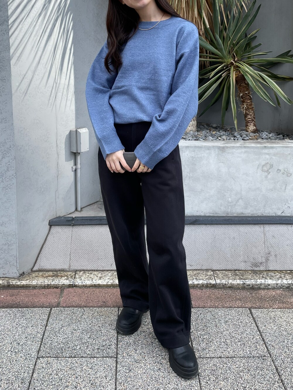 ブルー系のニット/セーター、ゴールド系のネックレスを着用したレディースの冬コーディネートの2枚目の写真