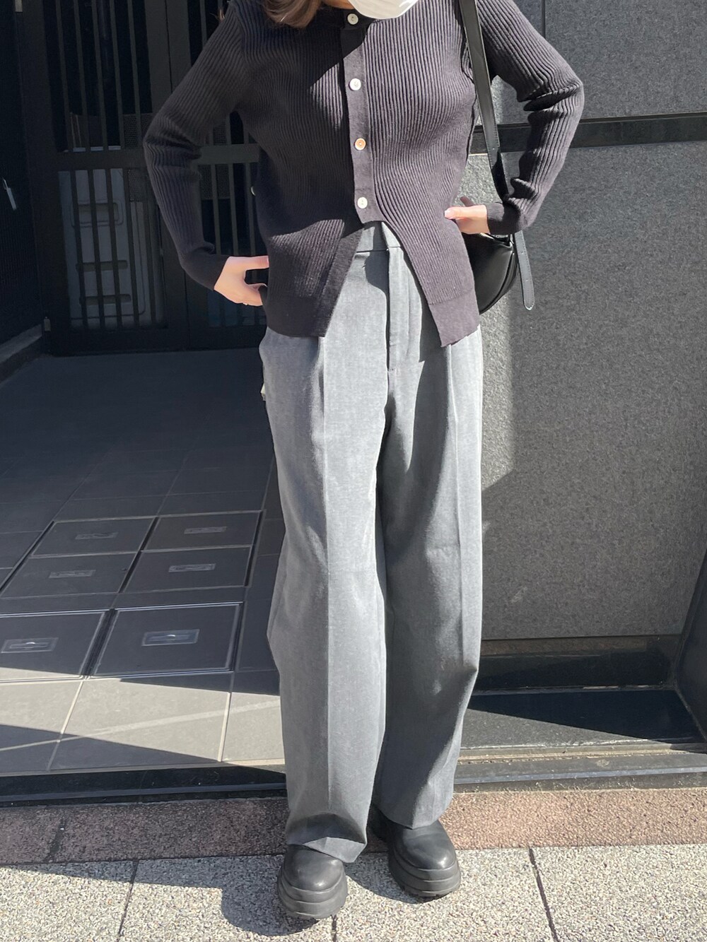 ブラック系のニット/セーターを着用したレディースの春コーディネートの2枚目の写真