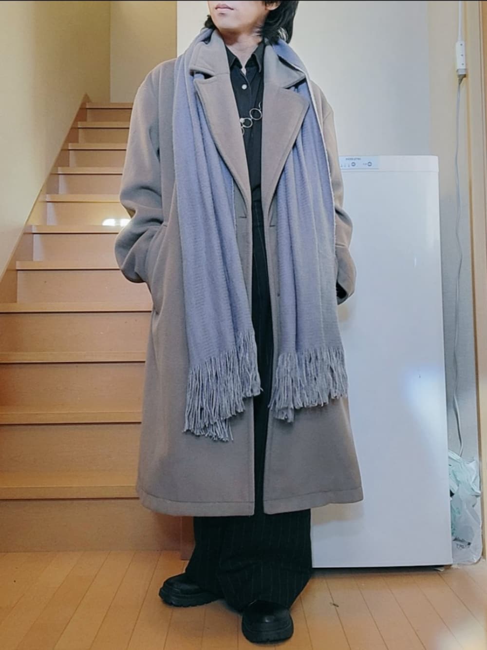 ベージュ系のチェスターコート、ブラック系のパンツ、ブラック系のシューズを着用したメンズの冬コーディネートの3枚目の写真